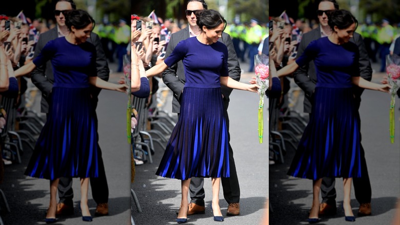 Meghan Markle wears a royal blue top and midi skirt