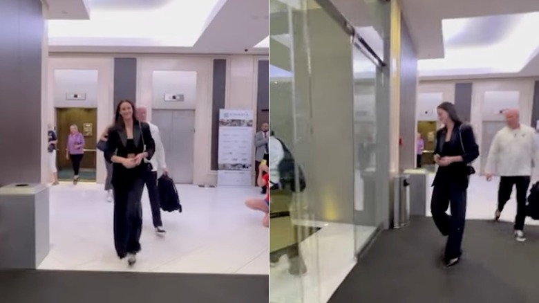 Caitlin Clark walking in wearing a three-piece black outfit