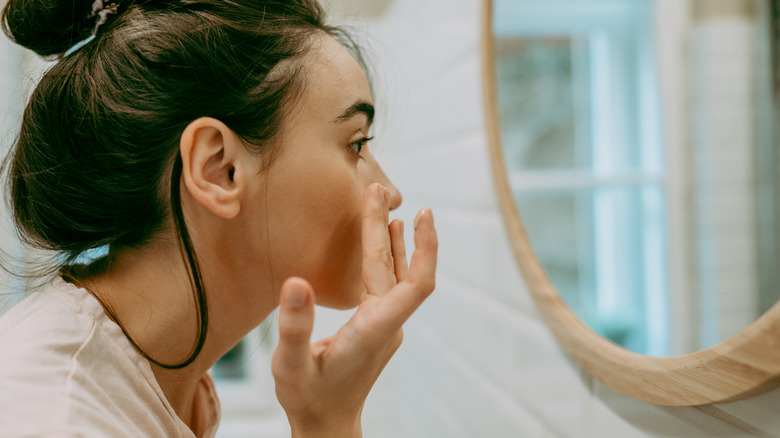 Woman moisturizing her face