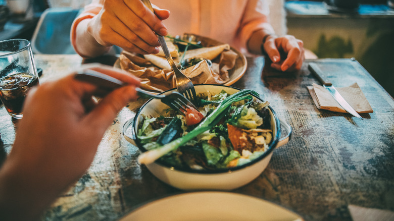 Couple eating salad at restaurant