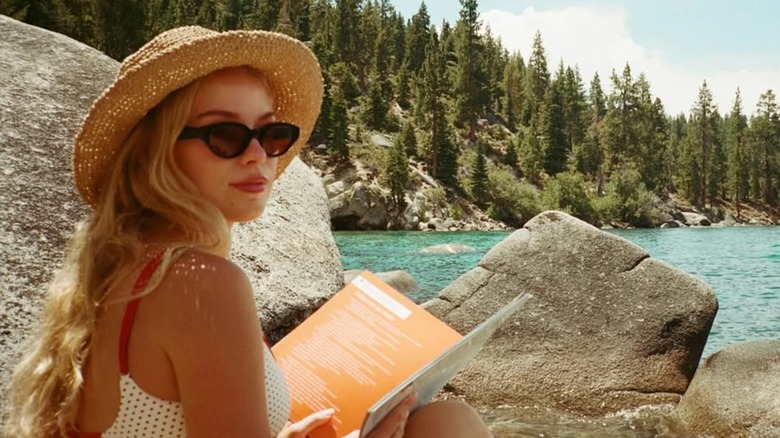 Elle Chapman poses for a picture by a lake.