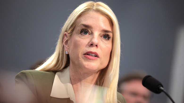 Pam Bondi speaks into a microphone during a meeting