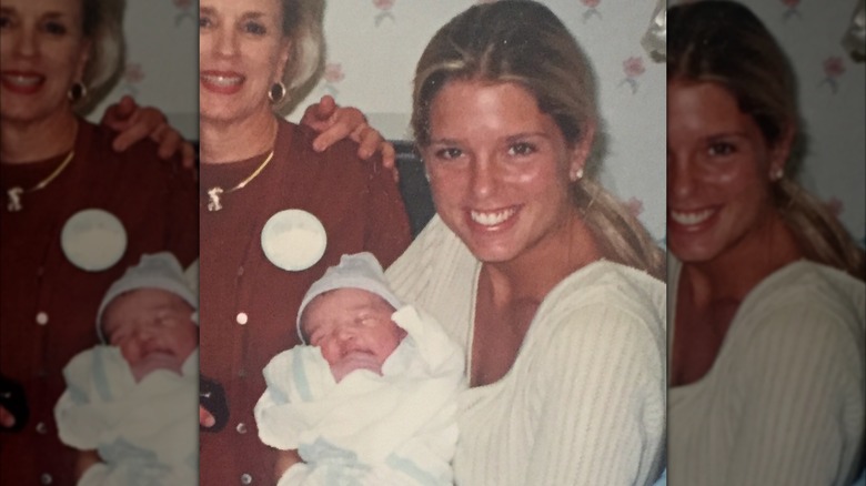 Young Pam Bondi smiles while holding a newborn baby