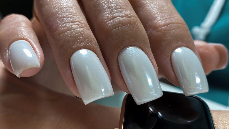 Hand with white pearl-inspired nails