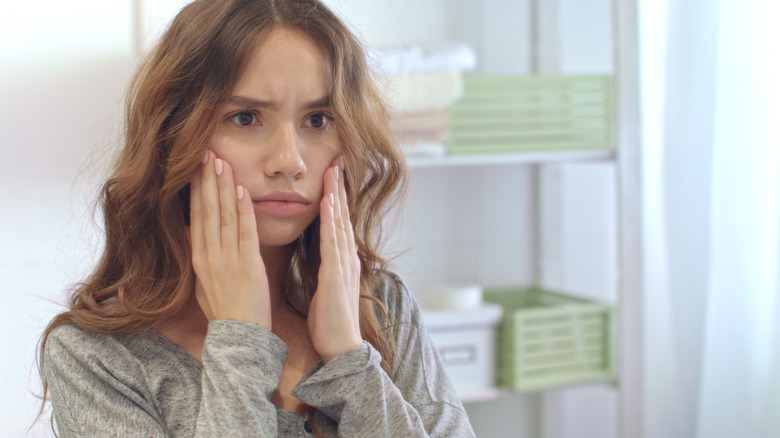 Woman touching her face