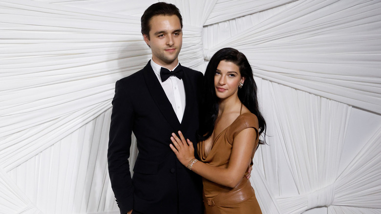 Phoebe Gates in brown dress posing next to former boyfriend Arthur Donald wearing a tuxedo