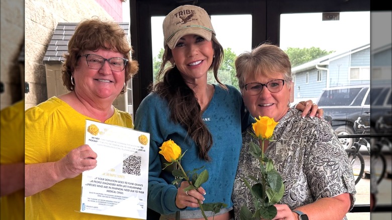 Kristi Noem is flanked by two friends while at a flower shop
