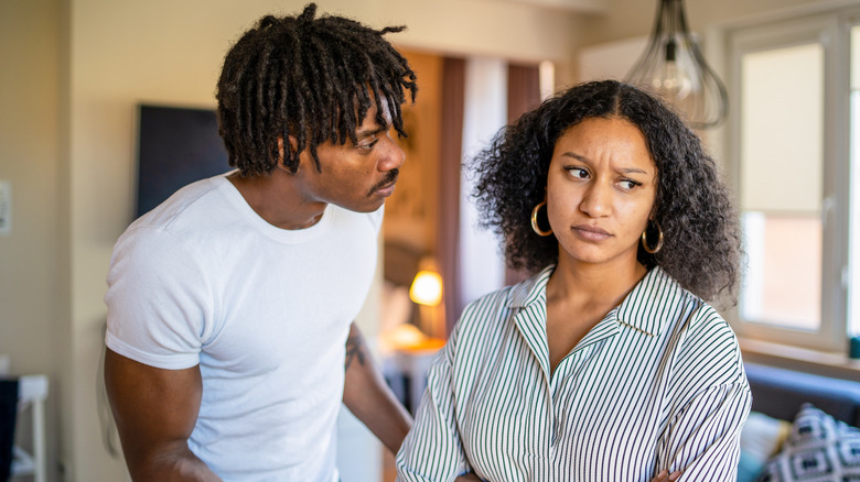 A couple arguing inside a living room.