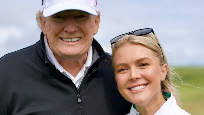 Donald Trump and Karoline Leavitt pose on a golf course in Scotland