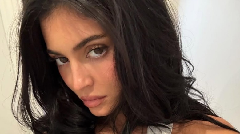 Kyie Jenner with a muted glam look and a white crop top