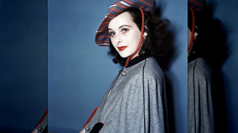 Hedy Lamarr wears a striped hat and gray coat