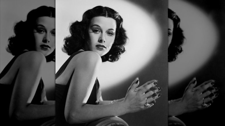 Hedy Lamarr poses for a 1938 photo wearing red lipstick, fluttery eyelashes, and a bold brow