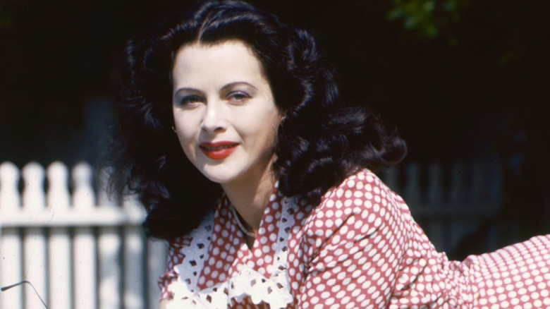 Hedy Lamarr lounges on a diving board wearing a gingham dress