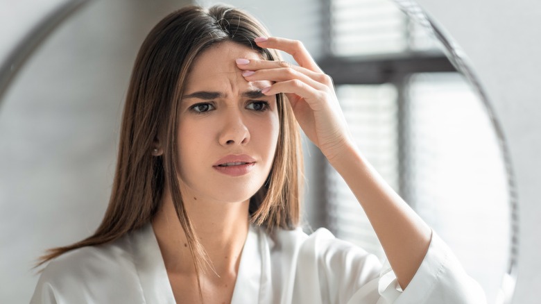 Woman frowning in mirror