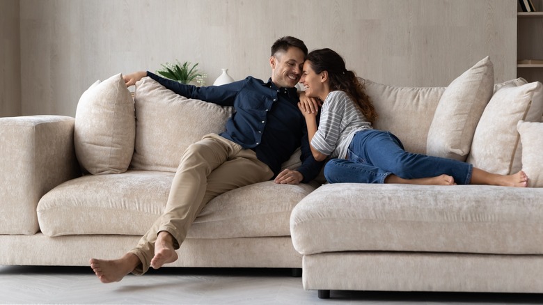 Two people cuddling on sofa