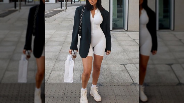 woman wearing a black blazer and beige playsuit