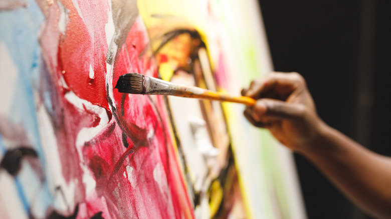 Person painting on canvas