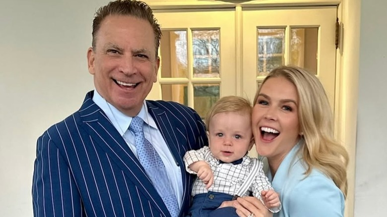 Karoline Leavitt and her husband smiling while holding their son