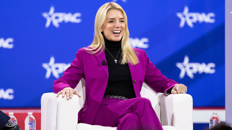 Pam Bondi smiles while sitting on stage