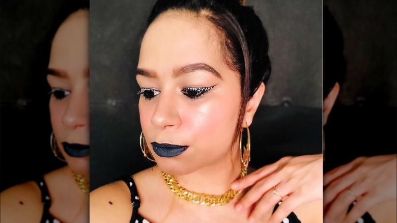 Woman models black eyeliner wing with white polka dots