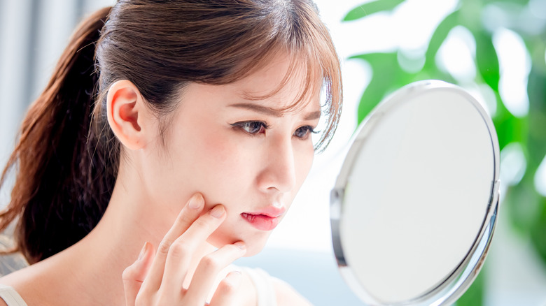 woman looking at oily skin