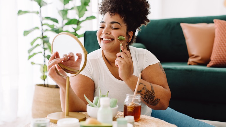 Woman using jade roller on face