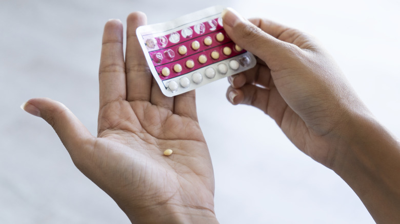 hands holding birth control pills