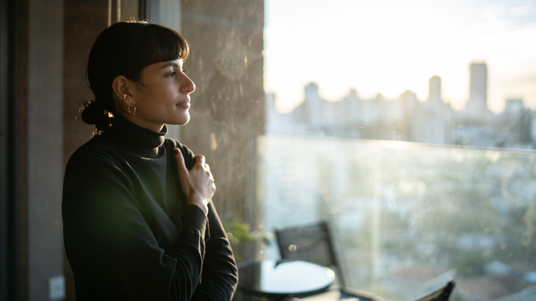 Woman looking out window at skyline