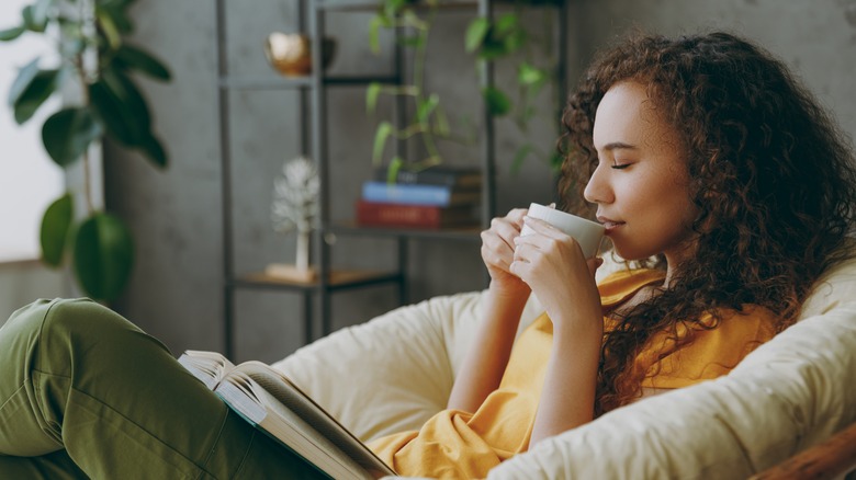woman enjoying beverage while reading