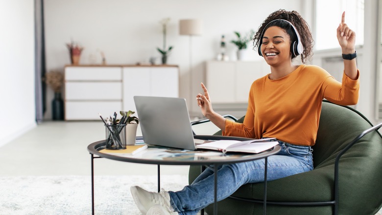 woman with laptop dancing