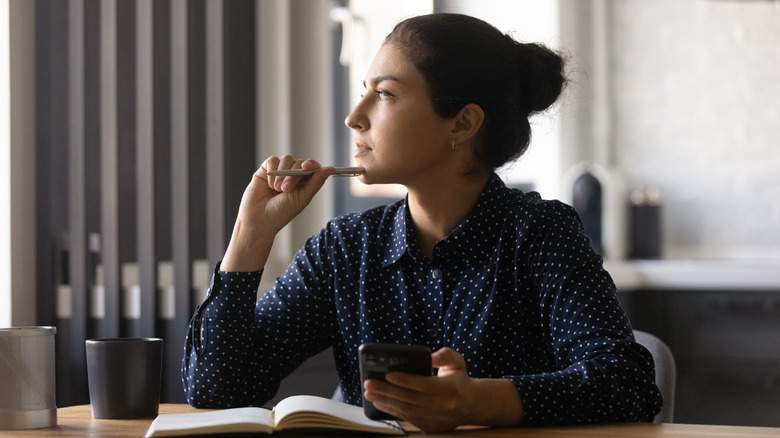 pensive woman holding phone