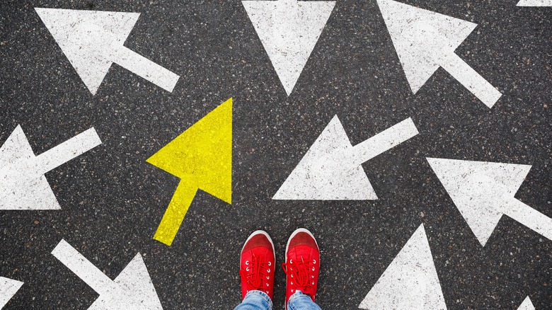 Person standing amongst arrows