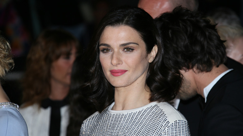 Rachel Weisz posing in a white outfit and red lipstick