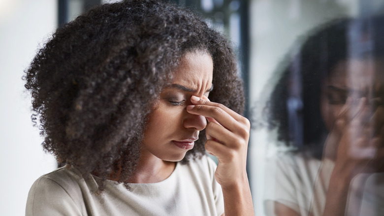 Stressed woman pinching nose