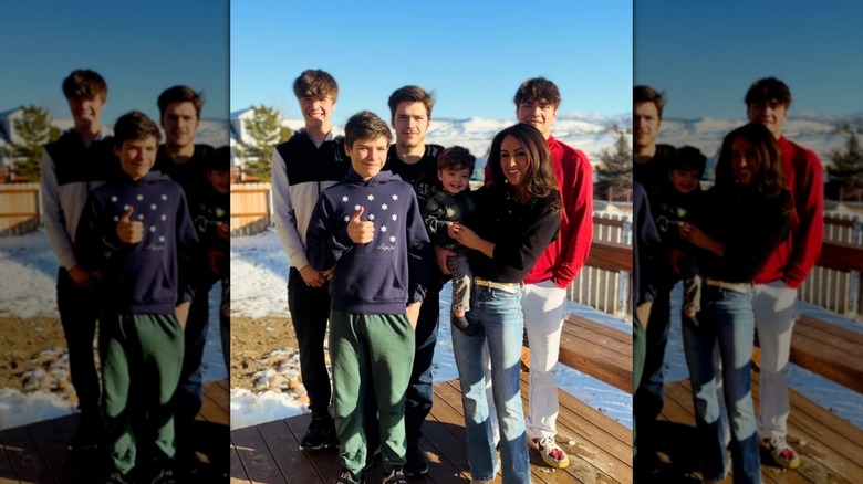 Lauren Boebert in jeans and a cardigan posing with her sons