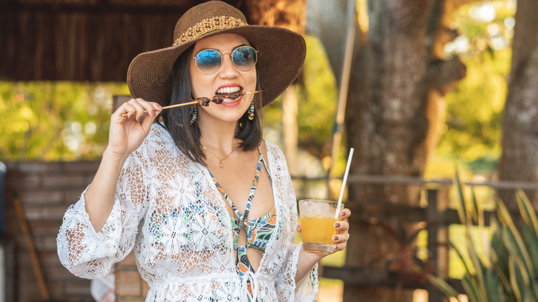Woman eating kabob at barbeque 