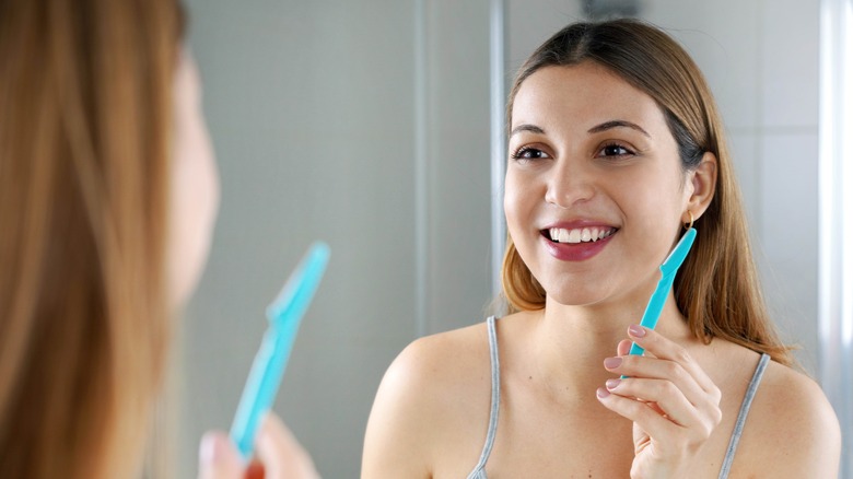 smiling woman dermaplaning skin