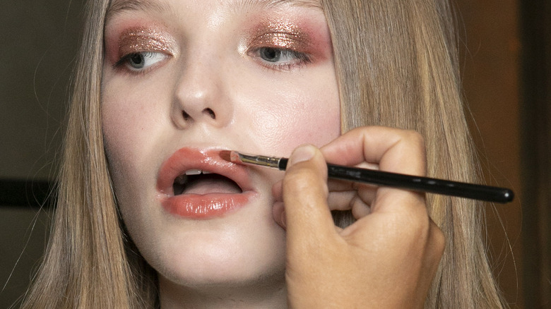 model getting lipstick retouched