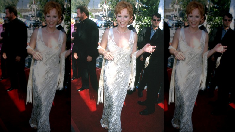Reba McEntire on the 1999 ACM Awards red carpet in a white netted dress.