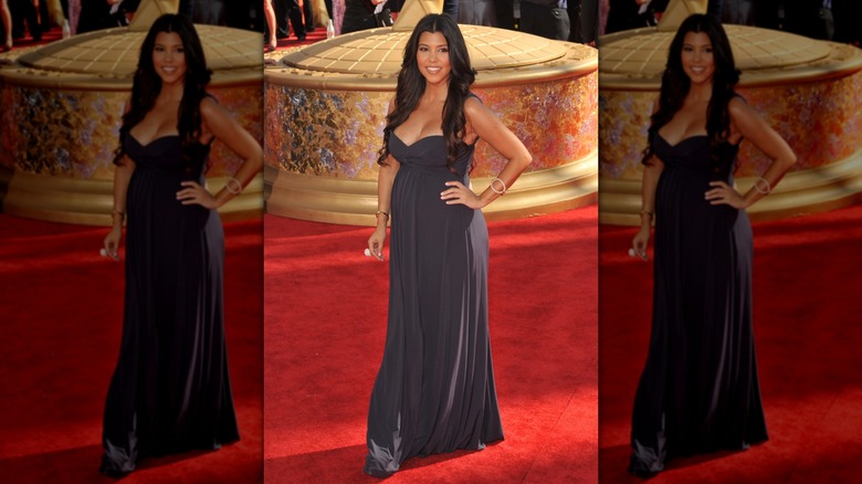 Kourtney Kardashian posing in a gray dress at the Emmys