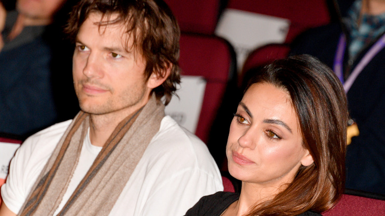Ashton Kutcher and Mila Kunis watching a show