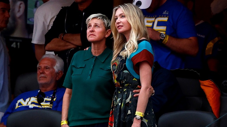Ellen DeGeneres and Portia de Rossi standing together in the stands at the 2022 Super Bowl.