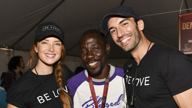 Justin and Emily Baldoni posing with a guest at the Skid Row Carnival of Love in 2019.