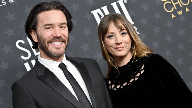 Kaley Cuoco and Tom Pelphrey posing together on a red carpet.