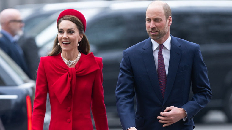 Kate Middleton in red and Prince William wearing a suit