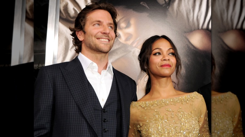 Zoe Saldaña and Bradley Cooper posing with their arms around each other.