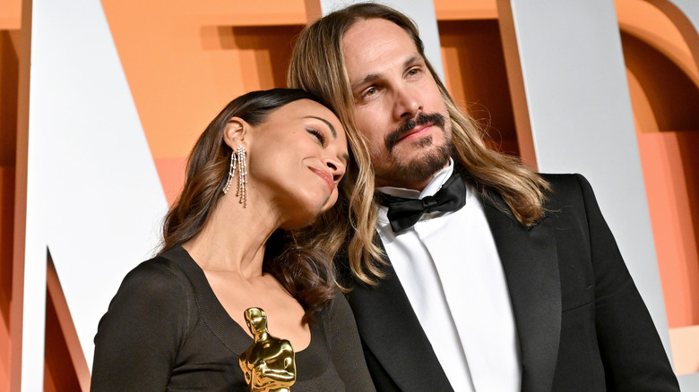 Zoe Saldaña leaning her head on Marco Perego-Saldaña's shoulder on the red carpet.