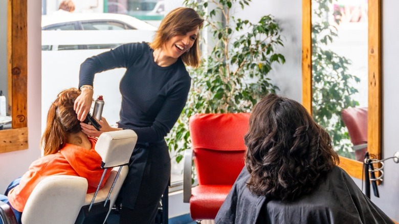A hairstylist chatting with another client