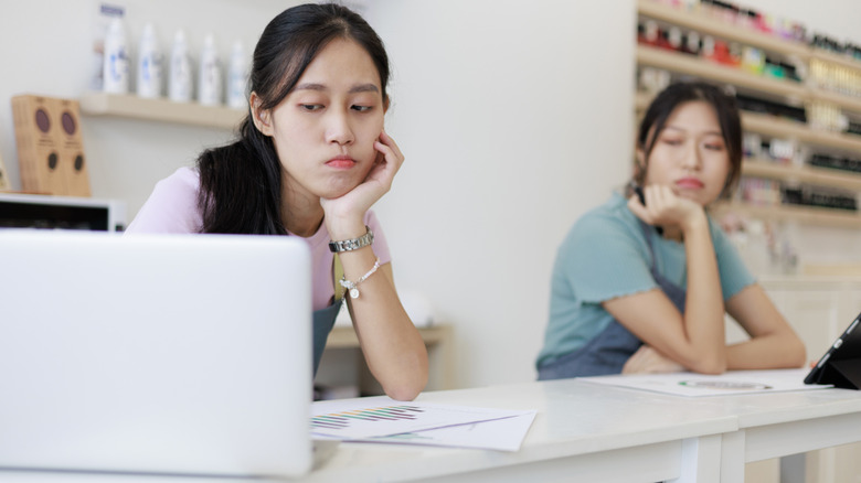 Two salon owners looking worriedly at their computer