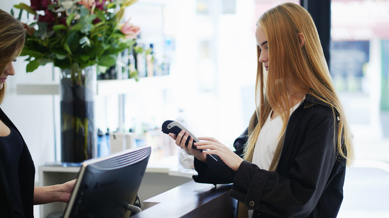 A woman paying at a hair salon